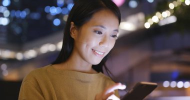 Genç kadın cep telefonuyla Hong Kong geceleri 