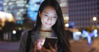 cep telefonuyla şehirde gece kadın 