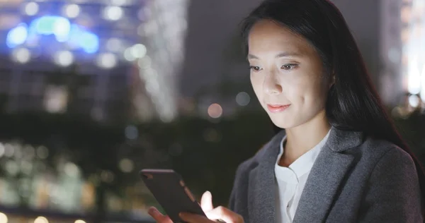 Asian businesswoman using mobile phone at night