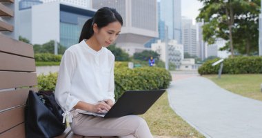 Şehirde dizüstü bilgisayar kullanarak iş kadını 
