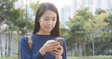 Şehir Parkı içinde smartphone kullanan genç kadın