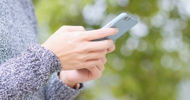 Park arka planda cep telefonu kullanan kadın 