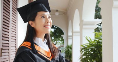 Üniversite Kampüsü mezuniyet elbisesi ile kendine güvenen kadın 