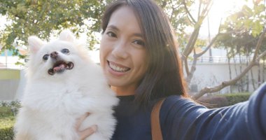 Selfie alma ve onun köpeği ile cep telefonu tutan kadın 