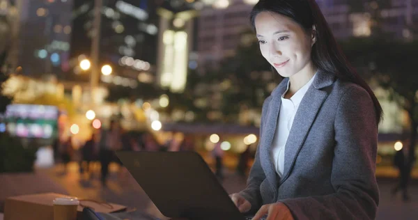 Woman using computer at night
