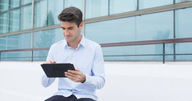 Tablet bilgisayar kullanan beyaz bir adam. 