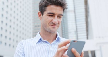 Şehirde cep telefonu kullanan bir adam 