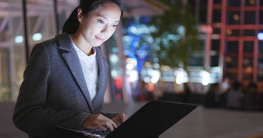 Businesswoman using notebook computer at night  clipart