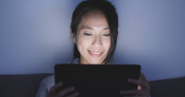 Geceleri tablet bilgisayar kullanan kadın 