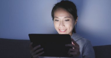 Evde tablet bilgisayarda izlerken kadın 