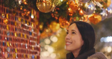 Genç kadın Noel ağacı süsle gece bakarak 