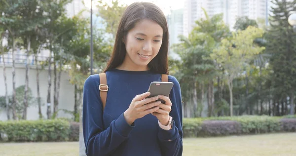 Genç kadın cep telefonunuzun ve Şehir Parkı 