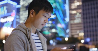 Gece şehirde cep telefonu kullanan adam 