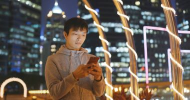 Geceleri cep telefonu kullanan adam. 