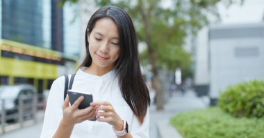 Şehirde Smartphone kullanarak iş kadını 