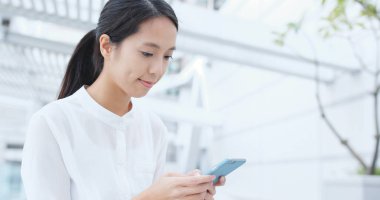 Elinde cep telefonu kullanarak iş kadını