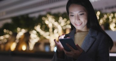 Gece akıllı telefon kullanan bir kadın. 