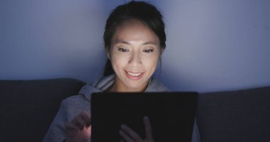 Kadın evde tablet bilgisayarda okuma 