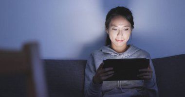 Geceleri tablet bilgisayar kullanan kadın 