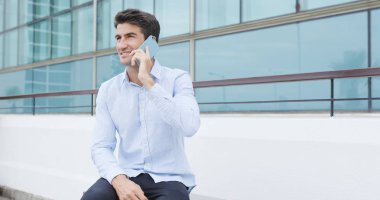 Ofis dışında cep telefonu üzerinde konuşan İspanyol adam 