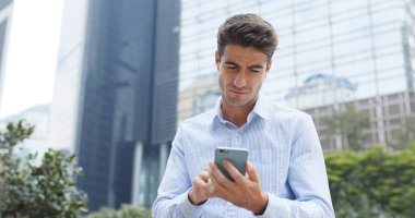 Şehirde cep telefonu kullanan bir adam 