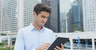 Tablet bilgisayar şehirde tutan işadamı 