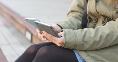 Meşgul kadın iki cep telefonu kullanarak tutmak 