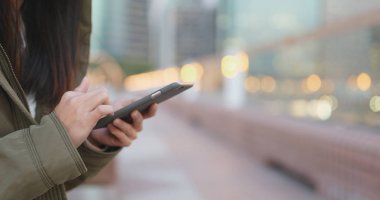 Kış saati, kadın giyiyor kış ceket adlı açık de akşam smartphone kullanarak kadının yakın çekim 