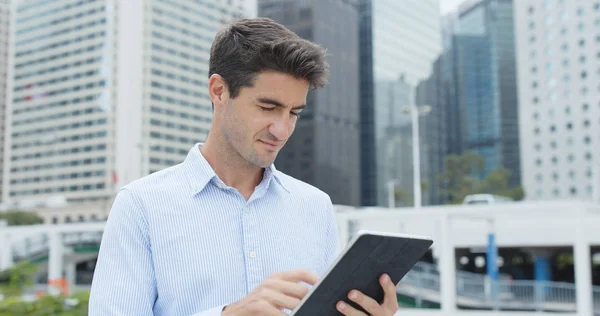 Businessman holding tablet computer in city