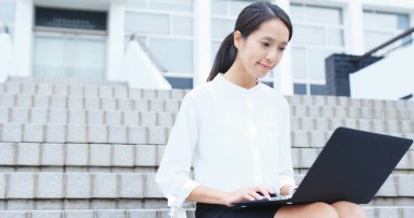 Açık, dizüstü bilgisayar üzerinde çalışan genç iş kadını 