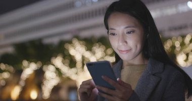 Asyalı kadın şehirde cep telefonu kullanarak 