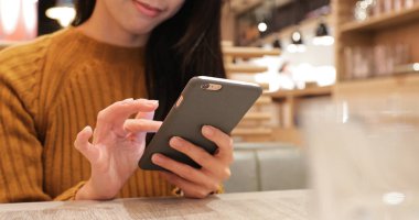 Restoranda cep telefonu kullanan kadın 
