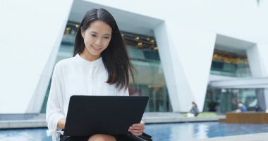 Açık, dizüstü bilgisayar üzerinde çalışan genç iş kadını 