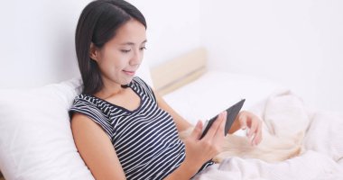 Yatakta onun köpeği ile tablet bilgisayar kullanan kadın 