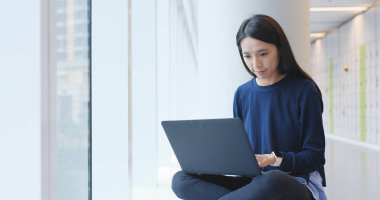 Üniversite binada dizüstü bilgisayar kullanan kadın 