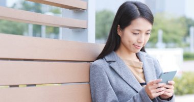 Cep telefonu kullanarak ve gülümseyen bir işkadını