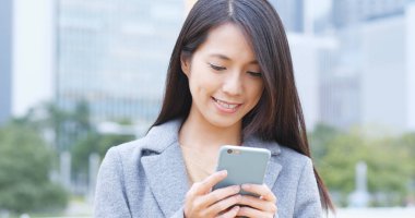 İşkadını şehir içinde hareket eden telefon bakmak 