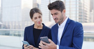 İşadamı ve cep telefonları birlikte seyir işkadını ve dizüstü bilgisayar, açık tutan iş kadın 