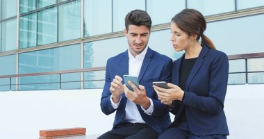 İşadamı ve birlikte, açık bilgi paylaşımı için cep telefonu kullanan kadın 