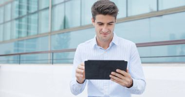 Tablet bilgisayar kullanarak adam ve kahve City ile tutun 