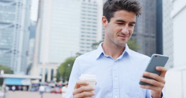 Hareket eden telefon tutarak ve kahve içme adam 