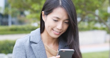 Şehirde akıllı telefon kullanan bir kadın 