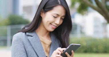 Şehirde akıllı telefon kullanan bir kadın 