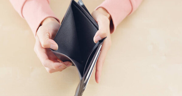 Woman opening empty wallet 