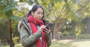 Earphones ile akıllı telefon kullanan kadın 