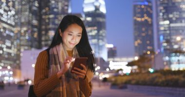 Cep telefonu şehrin üzerinde geceleri çalışan kadın 