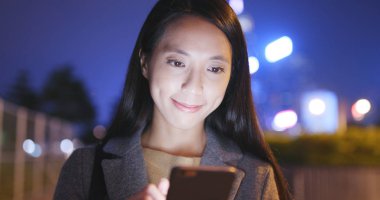 Geceleri cep telefonu kullanan kadın 