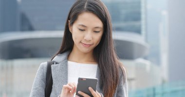 Şehirde akıllı telefon kullanan bir kadın 