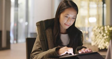 Geceleri dijital tablet bilgisayar kullanan kadın 