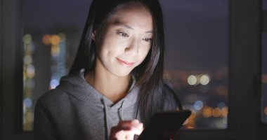 Kadın, evde cep telefonuna bak. 